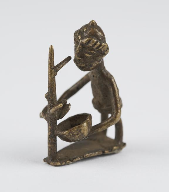 One of 84 Ashanti  brass weights in the form of a man drawing