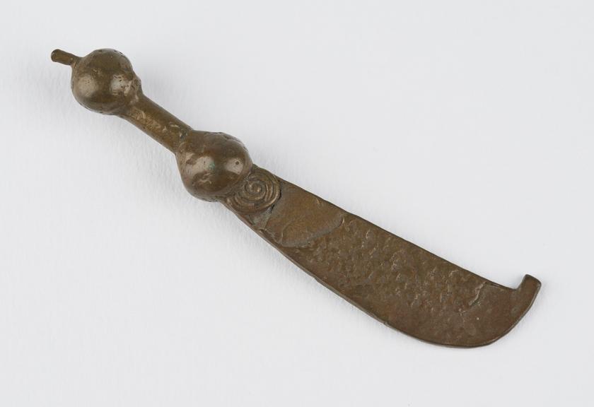 One of 84 Ashanti  brass weights in the form of a hooked sword.