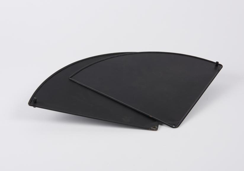 Two black painted metal quarter-circle shaped metal parts
