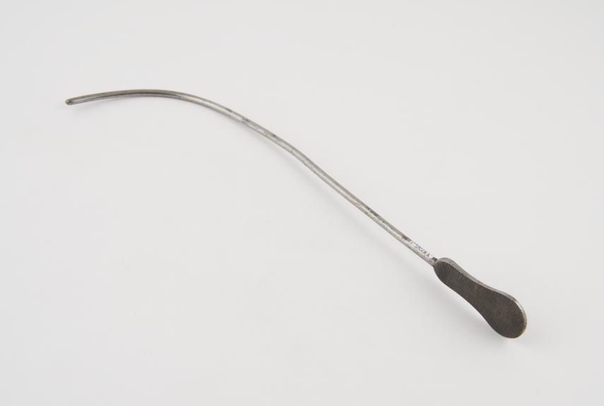 Curved lithotomy staff with median groove and flat handle