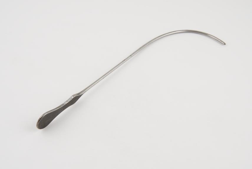 Curved lithotomy staff with median groove and flat handle