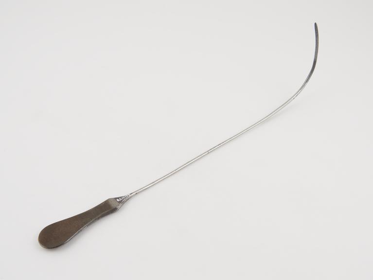 Curved lithotomy staff with median groove and flat handle