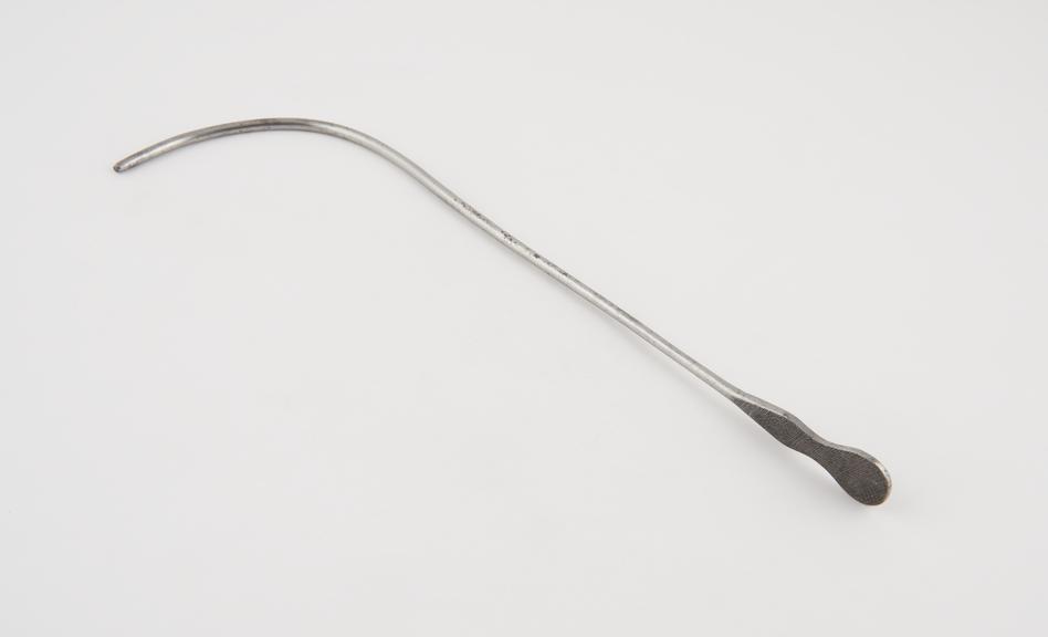 Curved lithotomy staff with median groove and flat handle