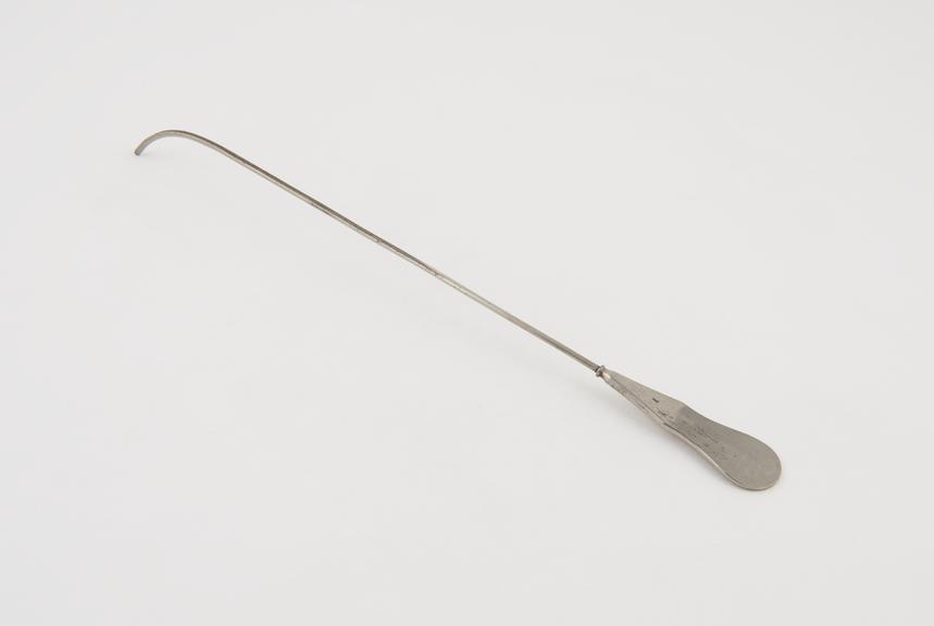 Small curved lithotomy staff with median groove and flat handle