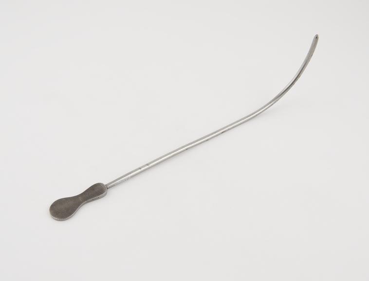 Curved lithotomy staff, with median groove and flat handle