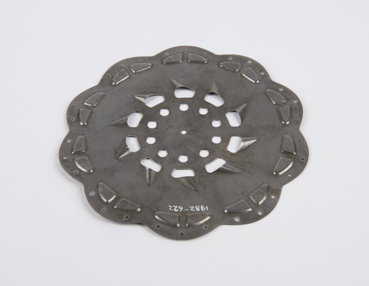 Circular stamped metal plate, slotted with round holes