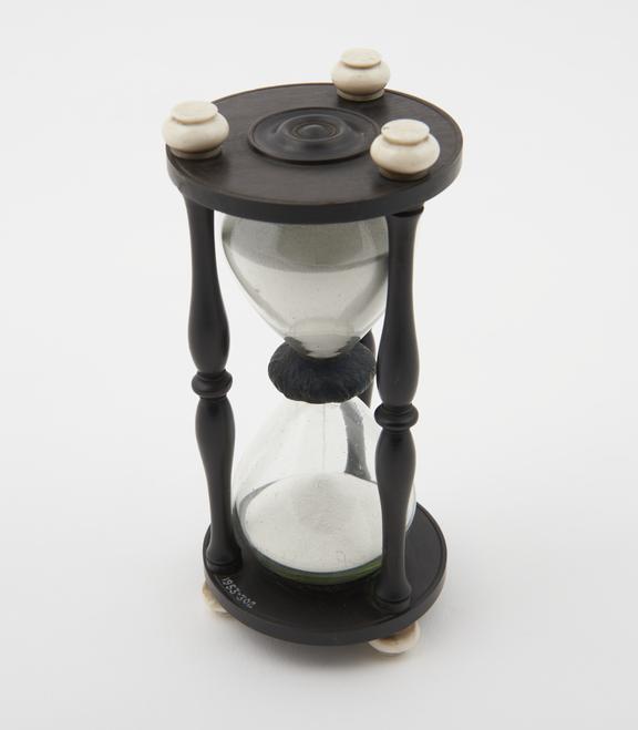 Single sand-glass in ebony mount with ornamental columns and