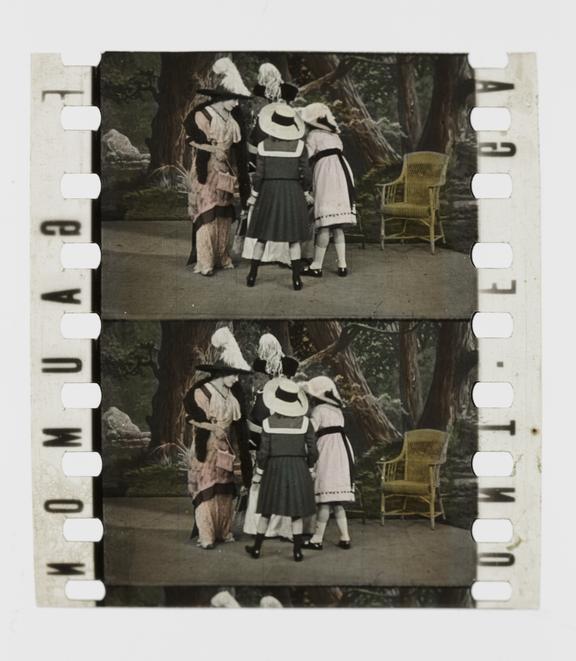 Two frames of 35mm silent stencil colour positive film showing