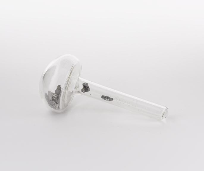 Mushroom shaped glass vial containing dysprosium