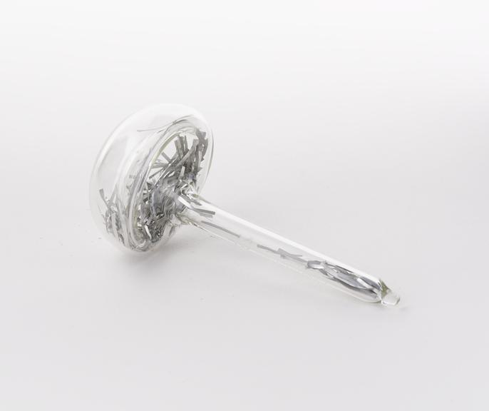 Mushroom shaped glass vial containing aluminium