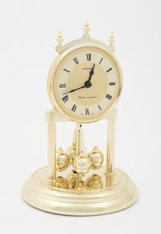 'Anniversary' clock with quartz analogue movement and decorative rotating pendulum