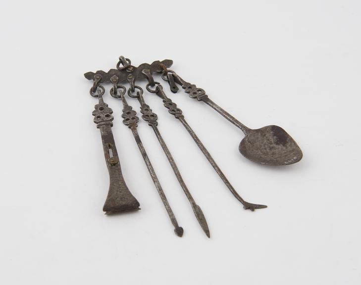 Set of 5 iron toilet implements hanging from thin metal strip