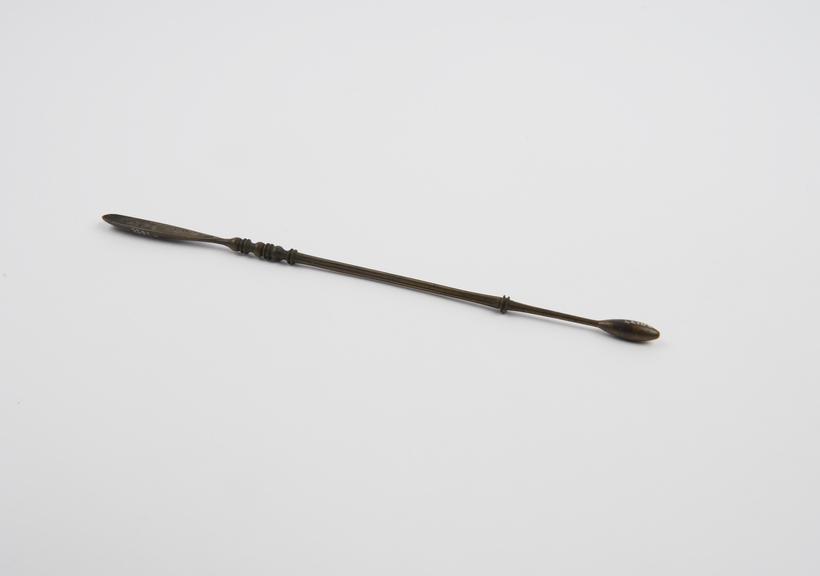 Bronze surgical instrument with a scoop at one end and a probe