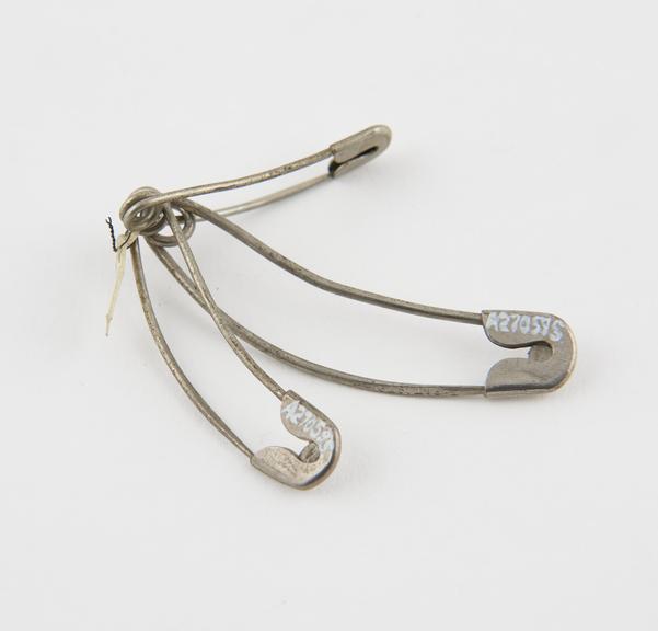 Four curved safety pins designed to avoid penetrating patient's