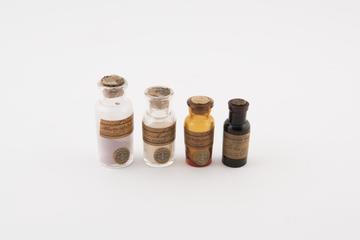 Four dyes in glass bottles with cork stoppers, 1800-1900