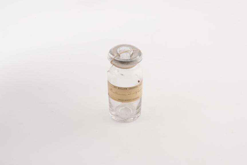 Glass bottle with glass stopper fixed with string containing a