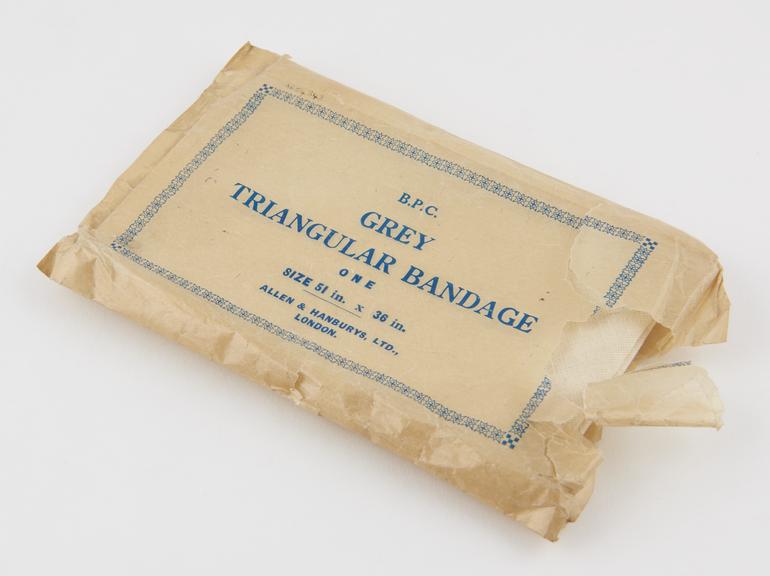 Triangular muslin bandage, folded in cellophane wrapper