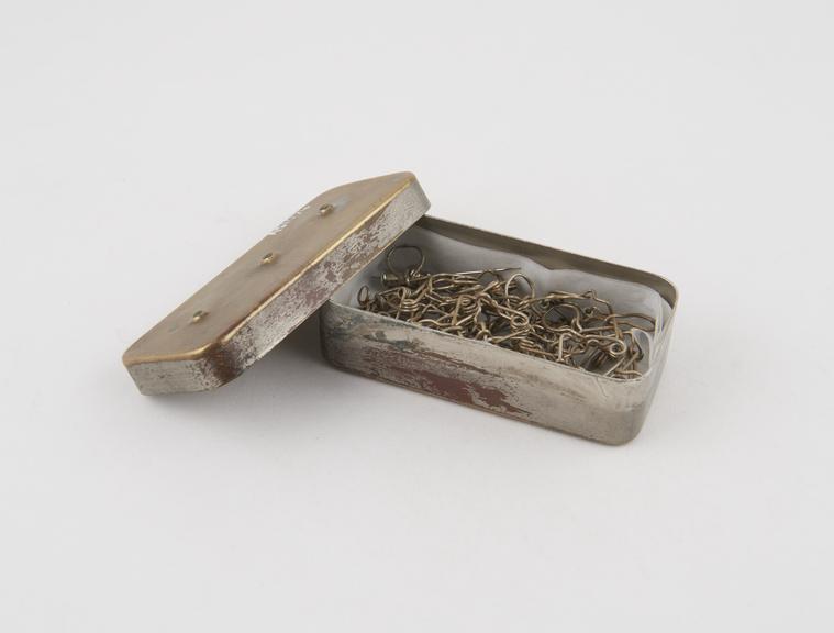 Suture clip, metal, in steel box, from Cuthbert collection