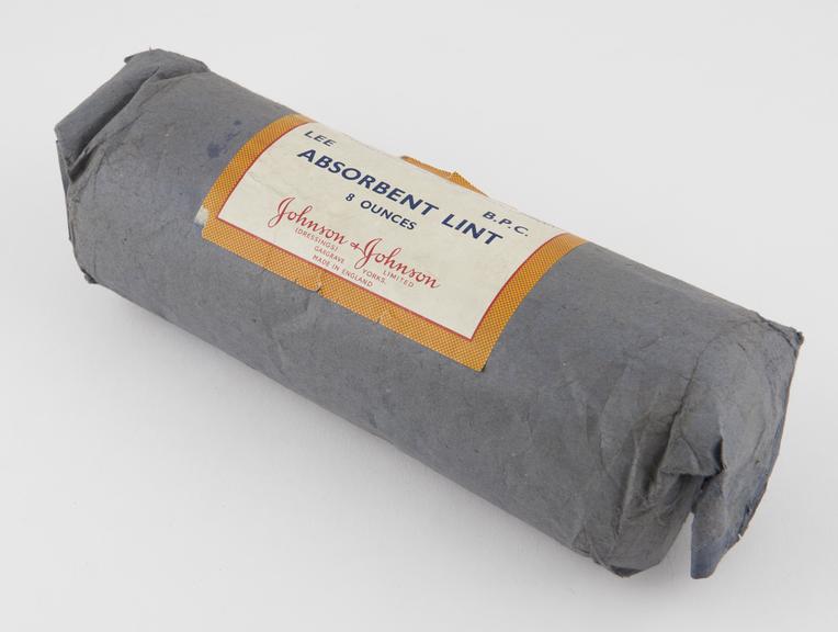 Roll of absorbent lint, in paper wrapping