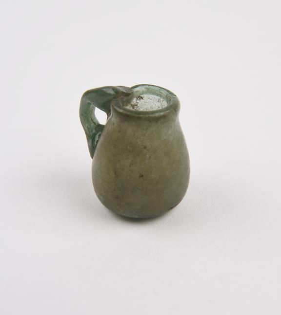 Glass jar, green, concave base, conical body, folded rim