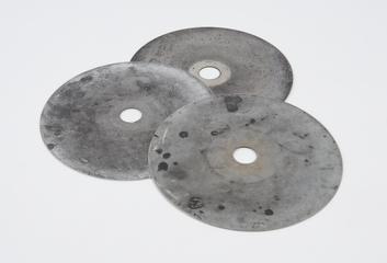 Metal recording discs from a clockwork motor and shutter assembly from Dobson Spectrophotometer