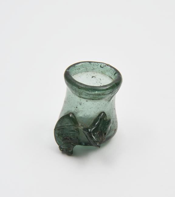 Glass jar, dark green, concave sides, concave base, folded rim