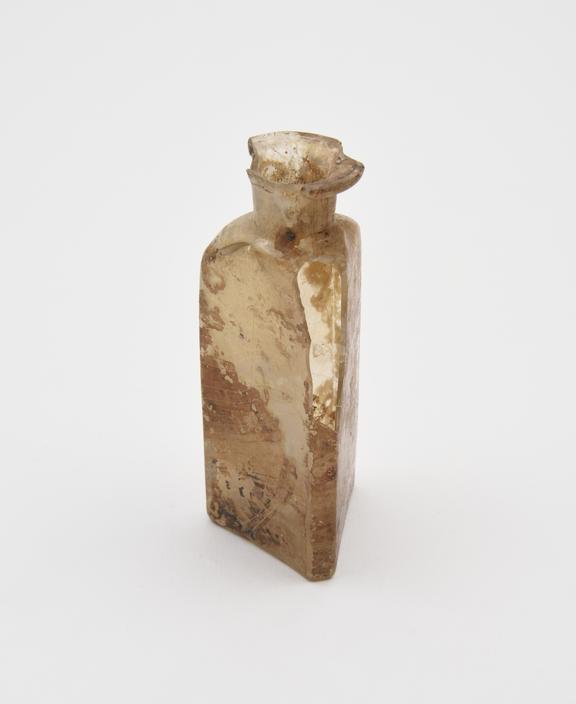 Glass bottle, pale yellow, triangular body, concave base