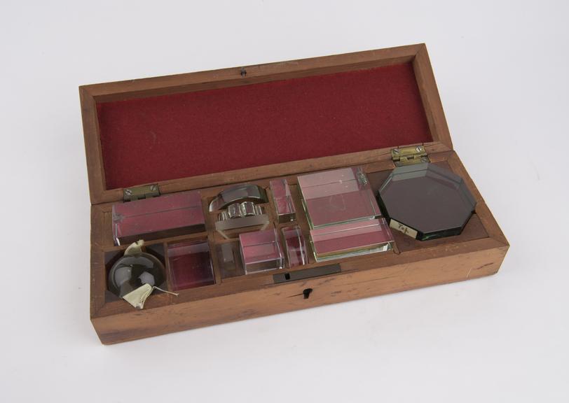 Wooden box containing 13 glass shapes for birefringence