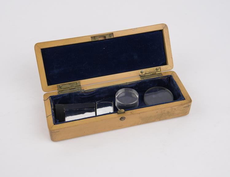 Wooden box containing two glass discs and two prisms