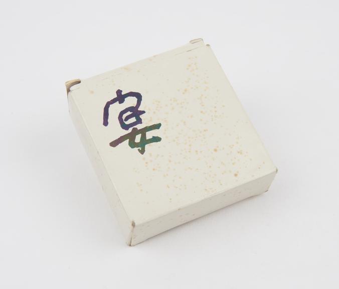 Small white carton with silver Japanese writing containing 3