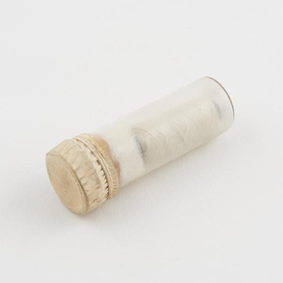 Suture in glass tube with cork stopper and parchment cover