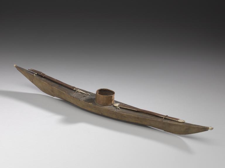 Model of leather-covered Inuit (eskimo) kayak with paddle and