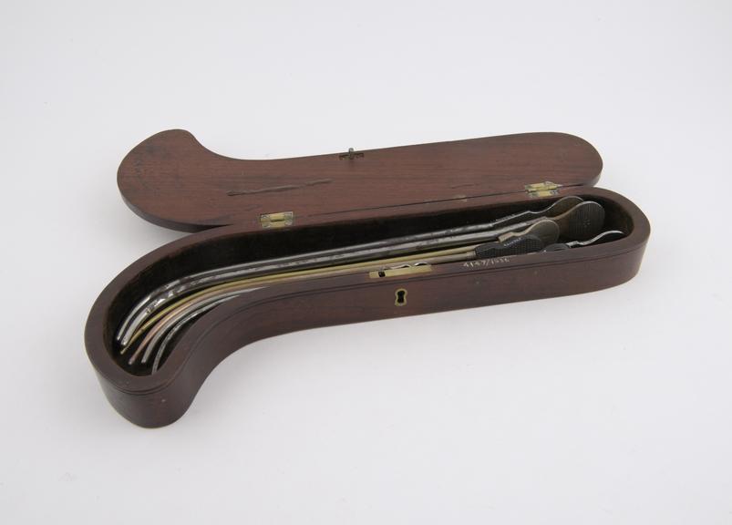 Set of 7 plated lithotomy sounds in pistol-shaped mahogany case