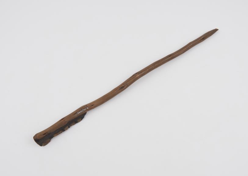 Ceremonial saw consisting of wooden stick with row of flints