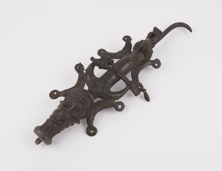 Bronze figurated staff with hooked iron grip and loop on top of