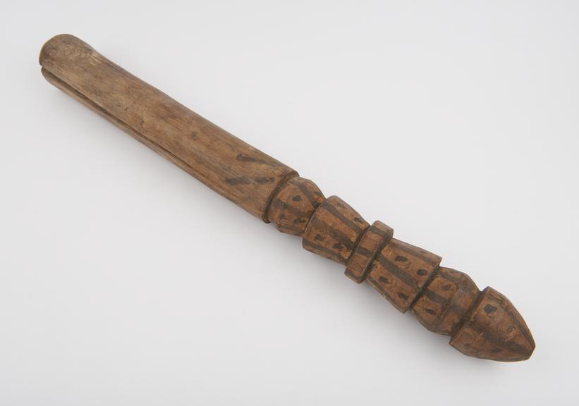 Wood pistle with painted design on handle, from Sumatra