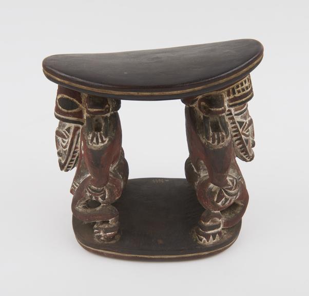 Head rest of carved wood with supports in form of stylised