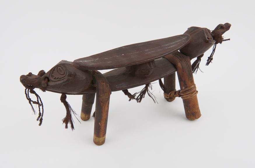 Carved wooden headrest, two-tier, with bent can legs