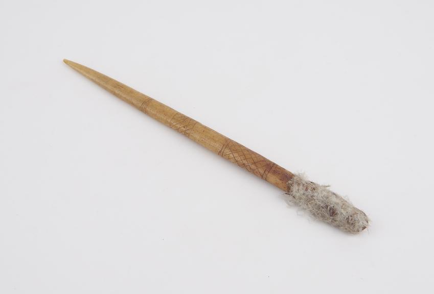 Pointing bone with cloth and feather-down at blunt end