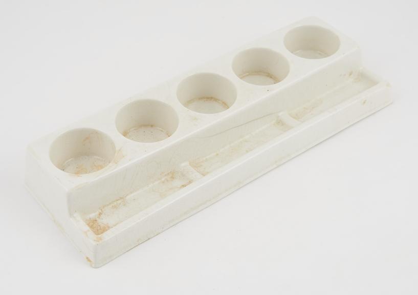 Ceramic bottle stand, by Hinders, English, 1945-1965