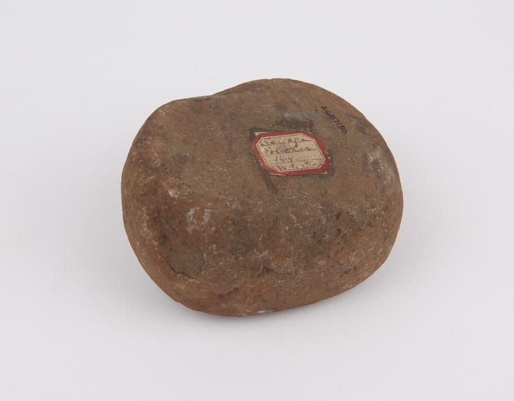 Roughly ovoid solid stone pounder with 2 flat surfaces