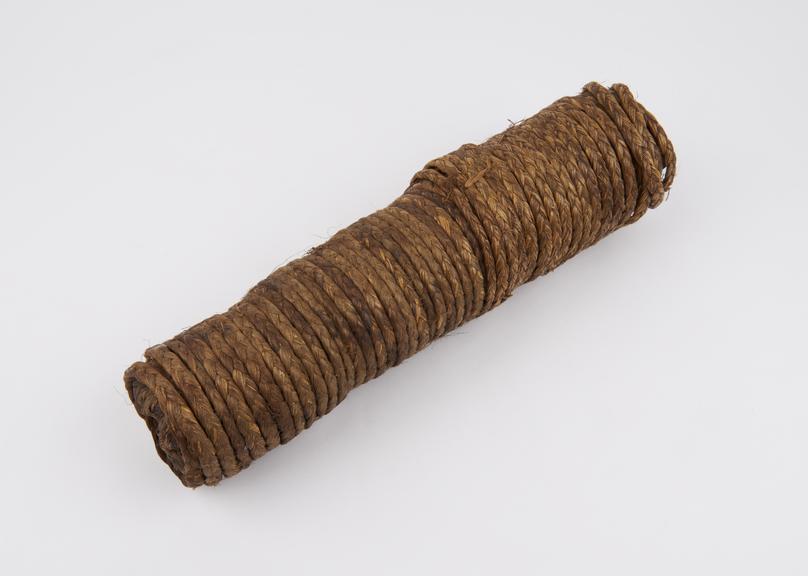 Tobacco roll, cylindrical, wrapped with rope