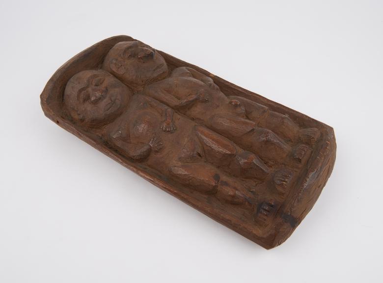 Amulet consisting of carved wooden cradle with male and female