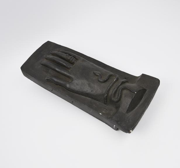 Black plaster replica of stone votive offering representing