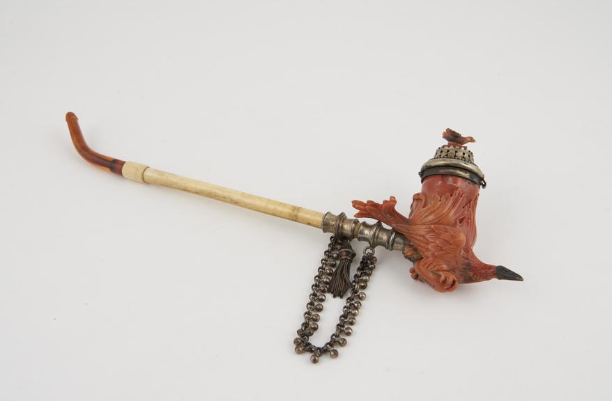 Coral tobacco pipe bowl in the form of a bird clutching an egg