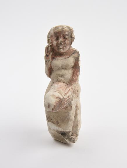 Carved limestone figure seated on a base