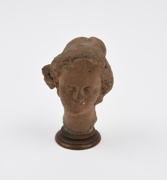 Votive female head, terra cotta, Roman, 200BC-200AD