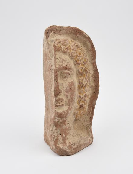 Votive face, left half, female, terracotta, Italy, 200BC-200AD