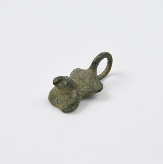 Amuletic bronze pendant with relief of male genitalia and