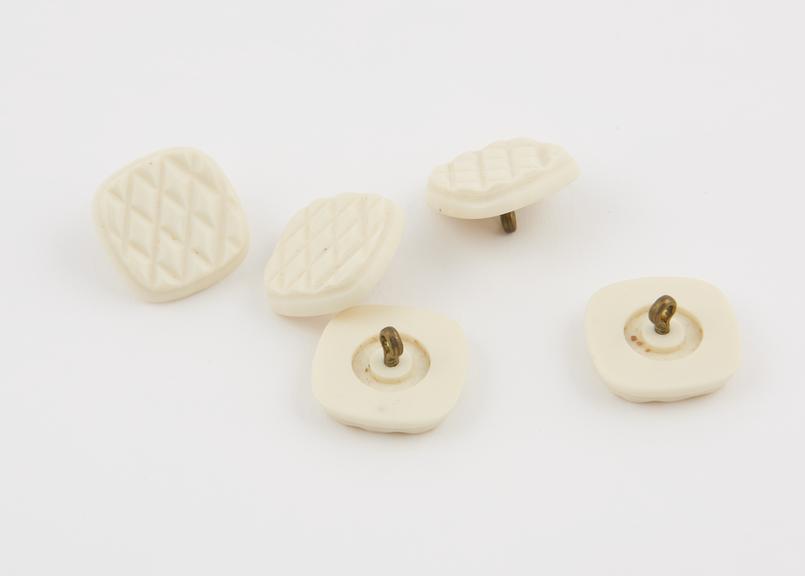 5 (five) embossed casein buttons coloured cream with brass